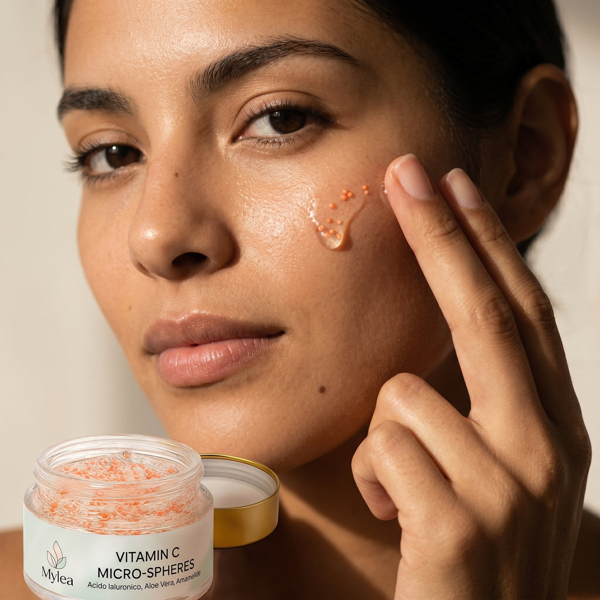 Modella applica il siero viso Mylea Vitamin C Micro-Spheres con sfere attive sulla pelle per un effetto luminoso